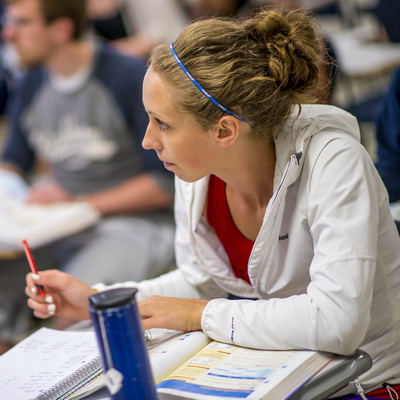 A student takes notes while in class.